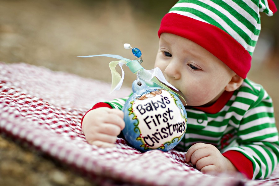 Baby chewing on ornament. Keep decorations out of reach for proper holiday safety.