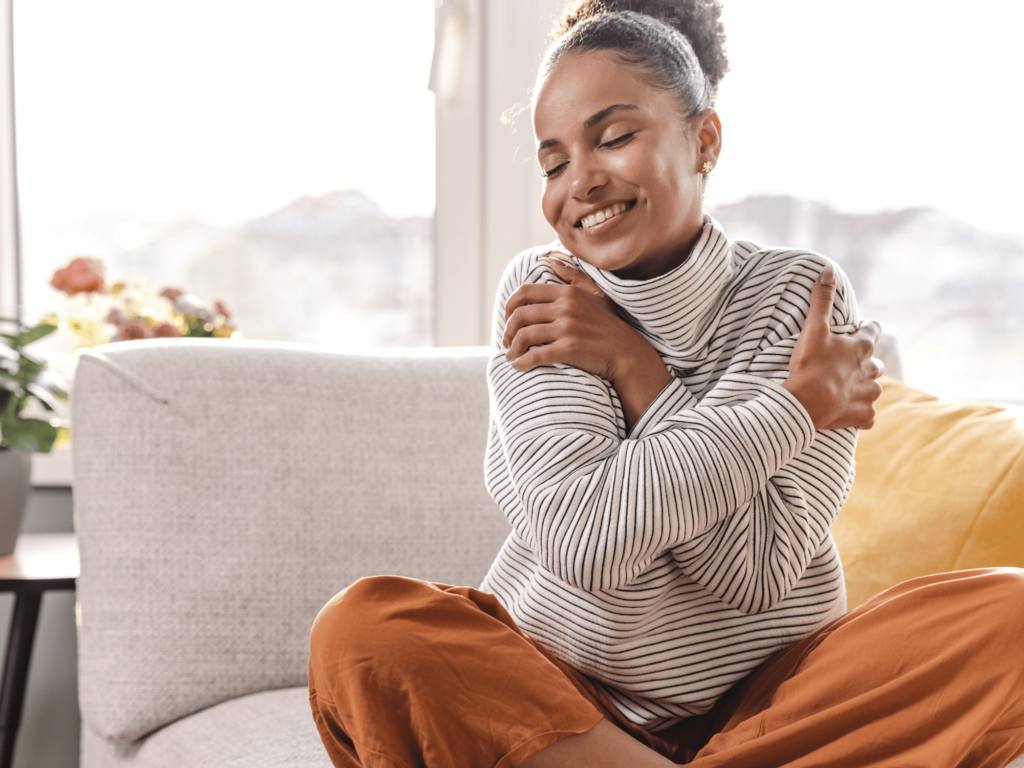 Woman hugging herself as a form of self compassion to stop yelling as a mom